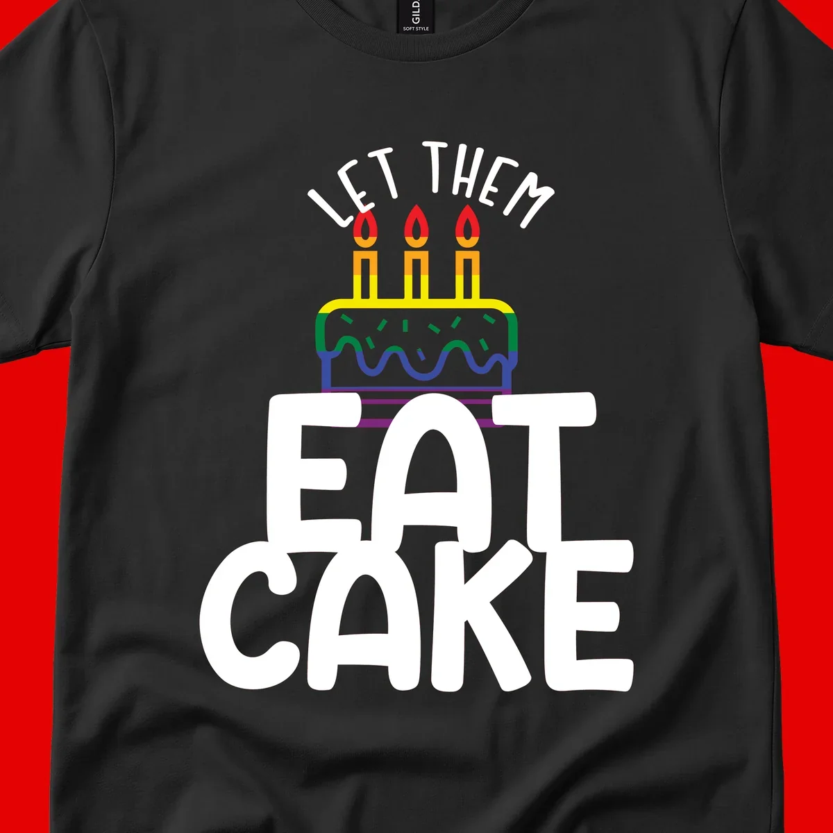 Rainbow-layered birthday cake with three candles above bold white text reading 'Let Them Eat Cake' - a Pride-themed design