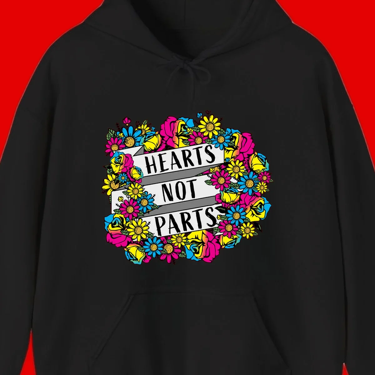 Hearts Not Parts pride design with colorful floral wreath featuring yellow daisies, magenta roses, and blue flowers surrounding bold statement text