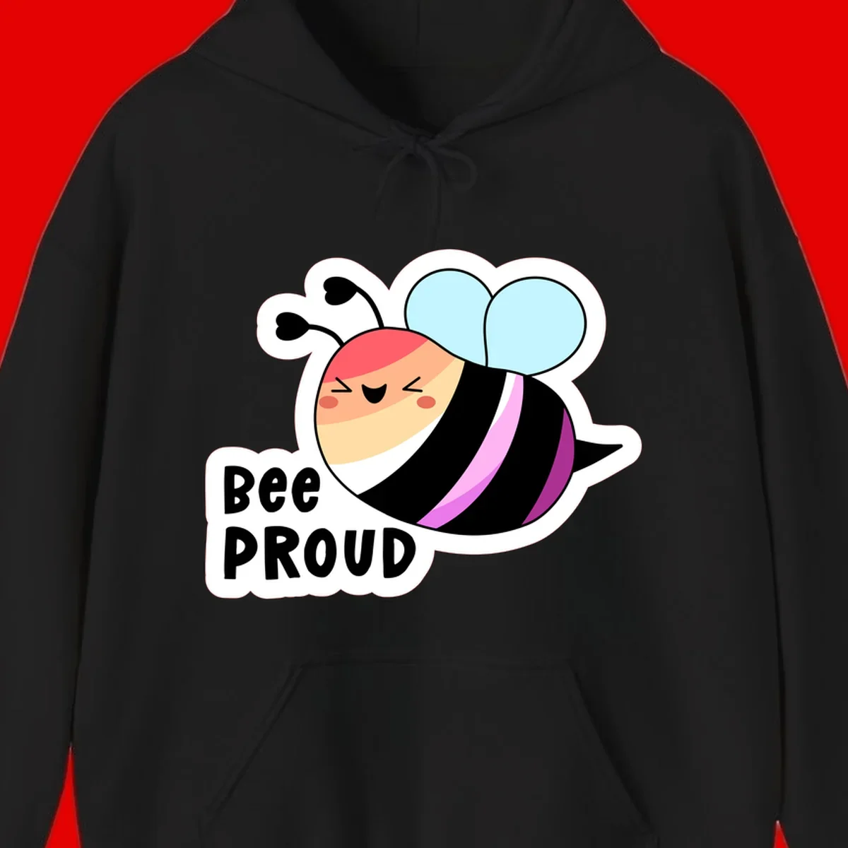 Cheerful cartoon bee with peach face and pink-striped body next to 'Bee Proud' text celebrating pride and individuality