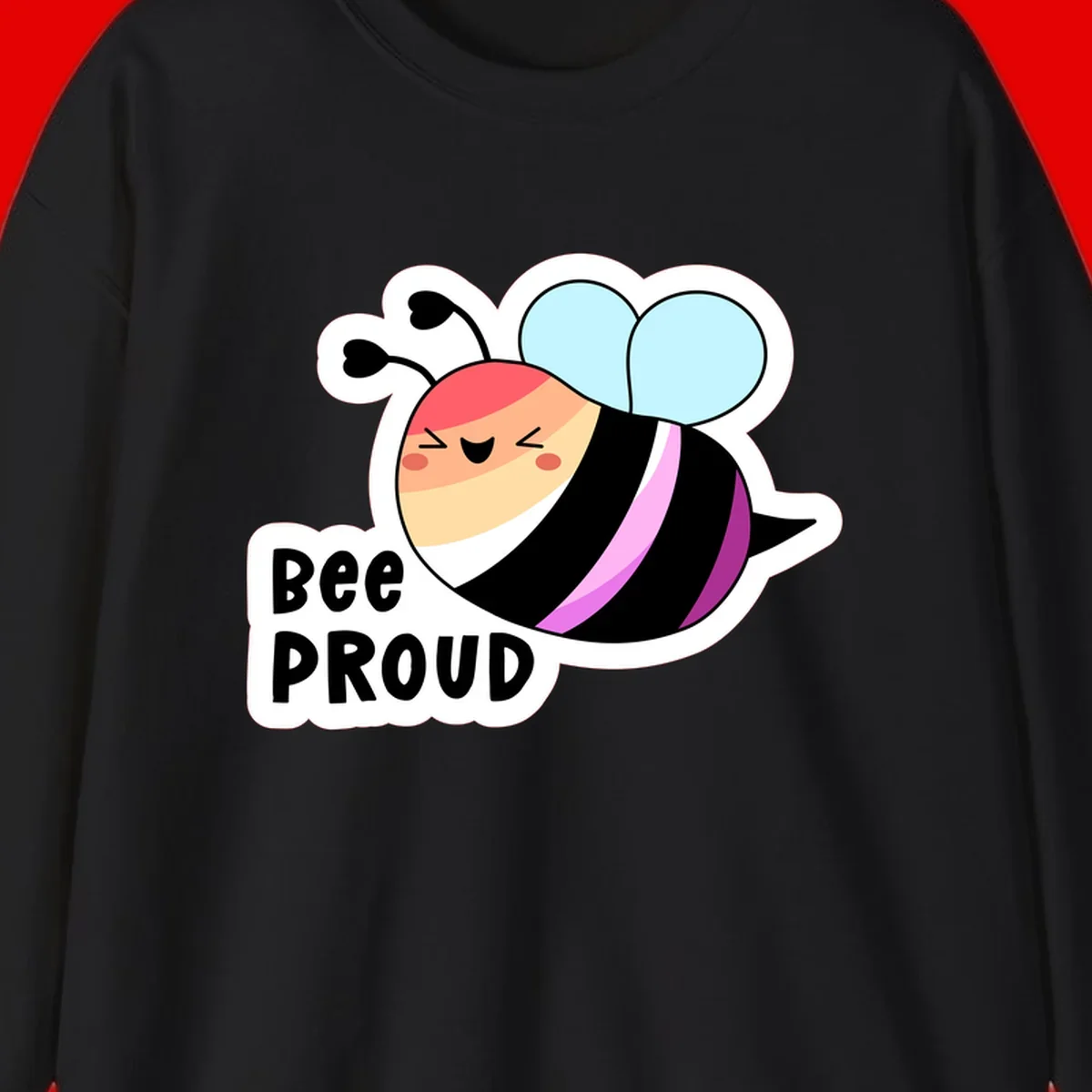 Cheerful cartoon bee with peach face and pink-striped body next to 'Bee Proud' text celebrating pride and individuality
