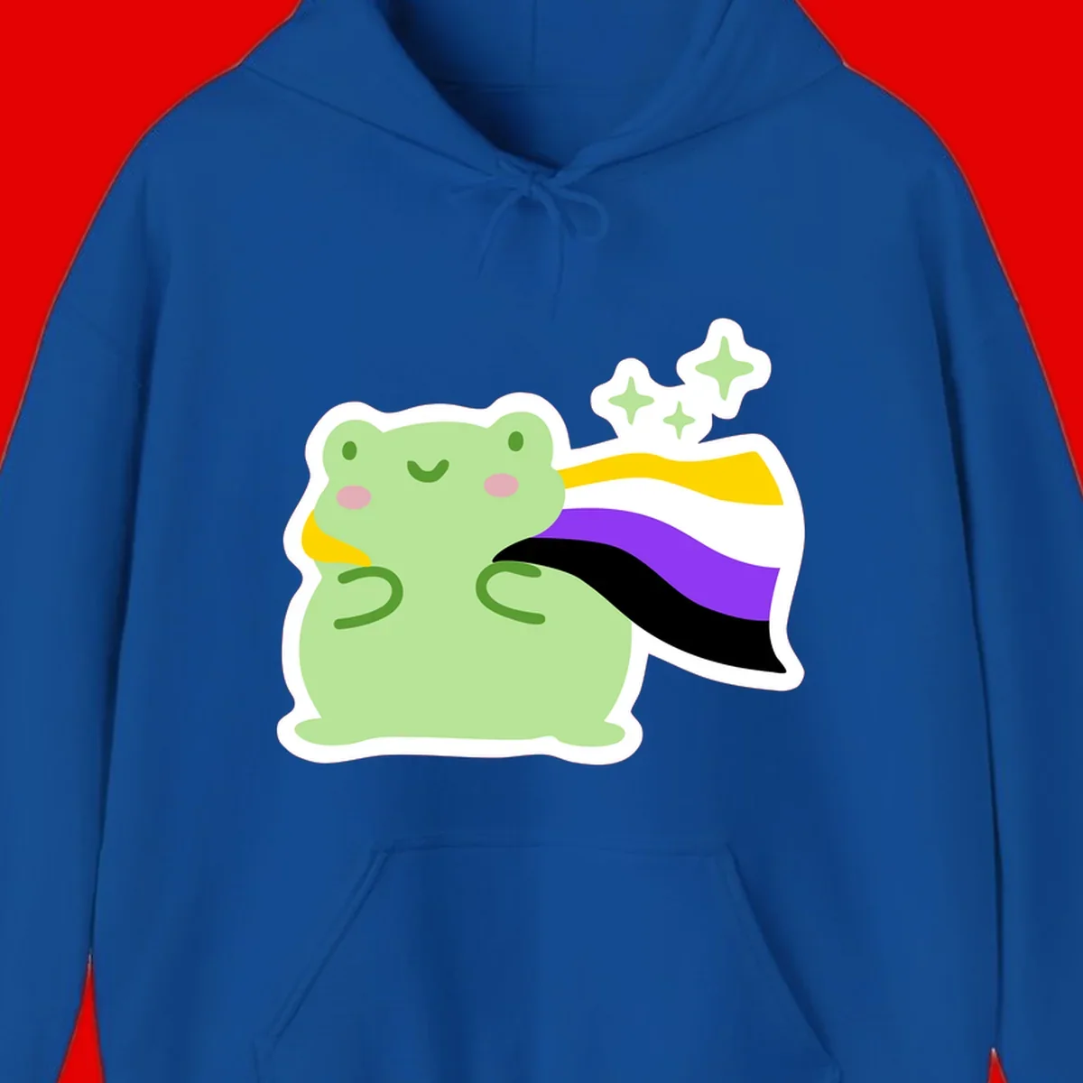 Cute green frog with pink cheeks wearing a yellow, purple, and black rainbow cape with floating sparkle stars