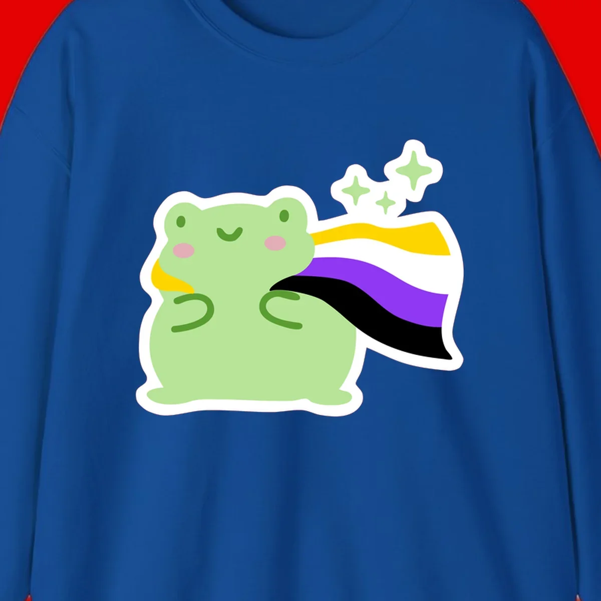 Cute green frog with pink cheeks wearing a yellow, purple, and black rainbow cape with floating sparkle stars
