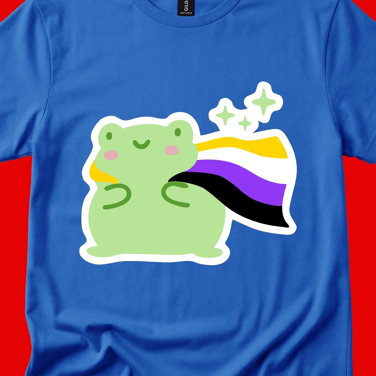 Cute green frog with pink cheeks wearing a yellow, purple, and black rainbow cape with floating sparkle stars