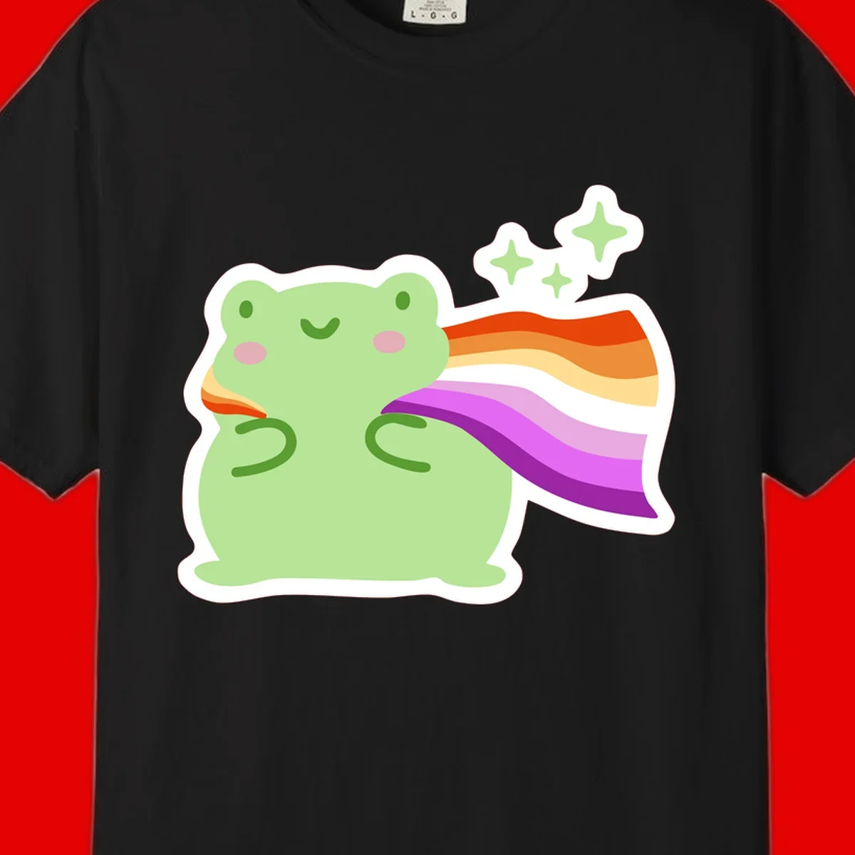 Cute green frog with pink cheeks wearing a rainbow pride cape, surrounded by sparkle stars