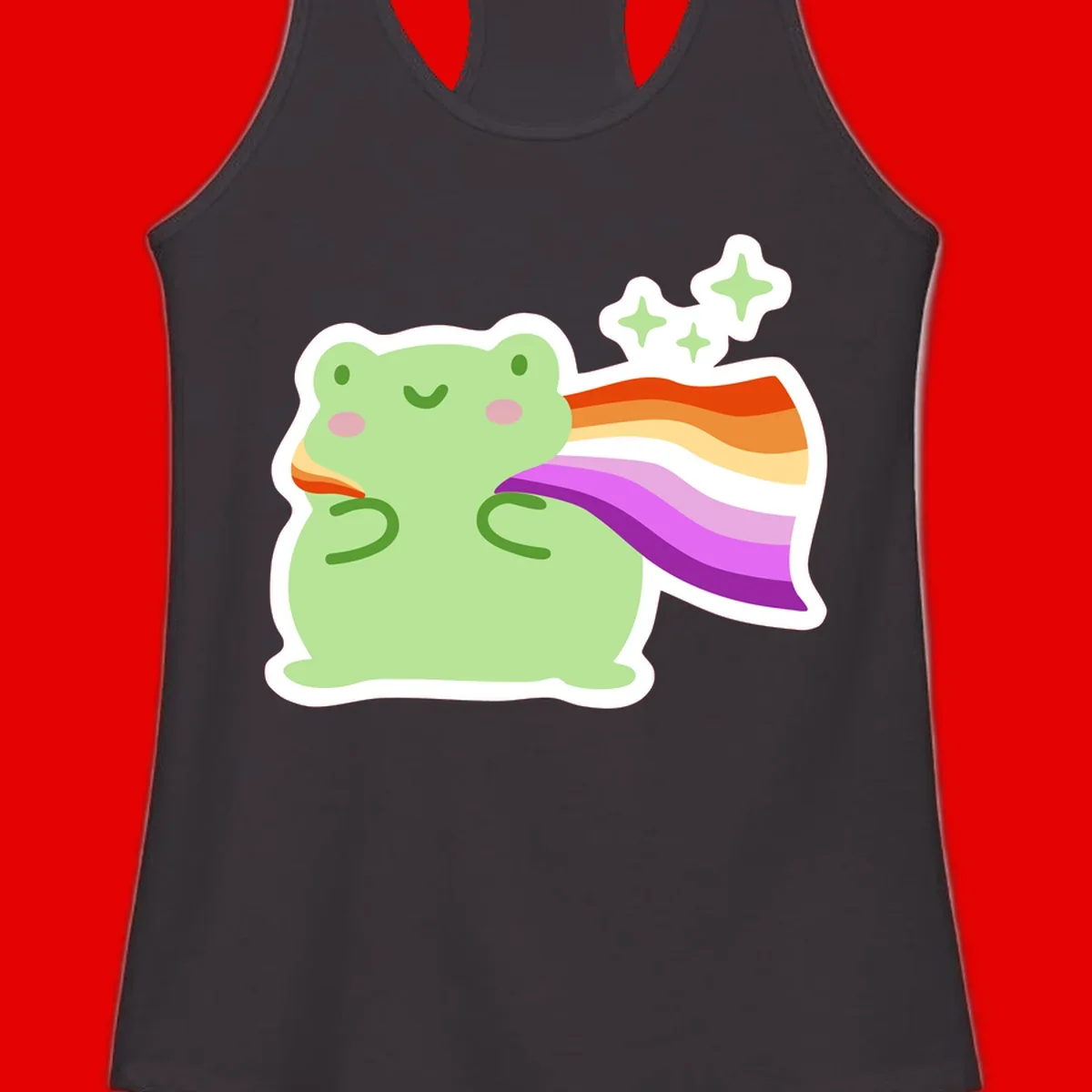 Cute green frog with pink cheeks wearing a rainbow pride cape, surrounded by sparkle stars