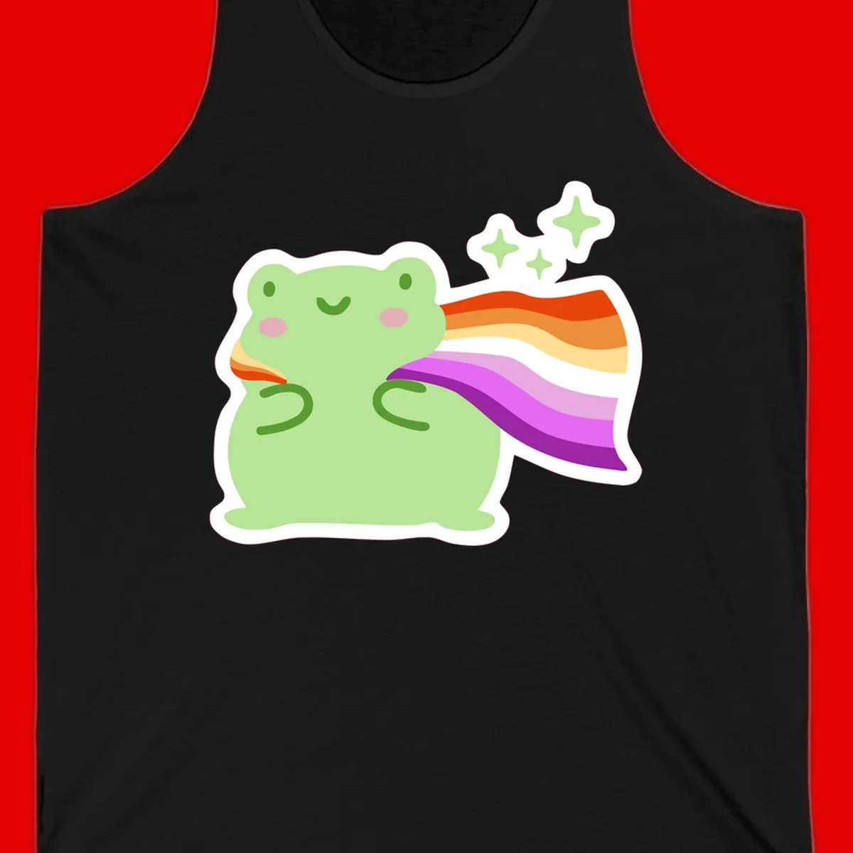 Cute green frog with pink cheeks wearing a rainbow pride cape, surrounded by sparkle stars