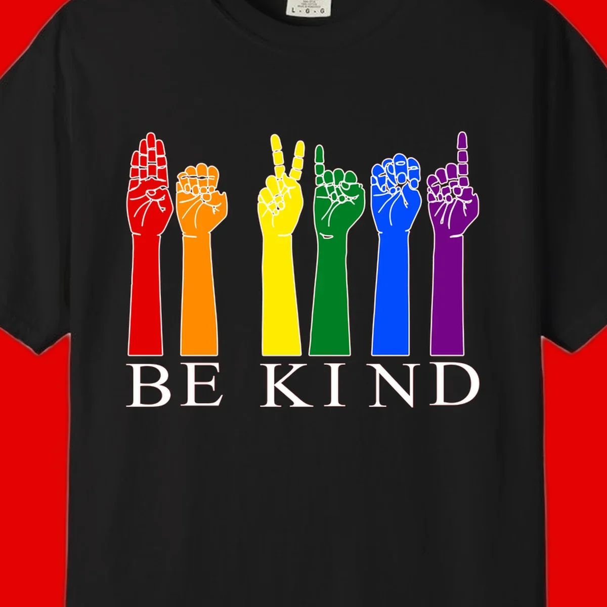 Six rainbow-colored raised hands in red, orange, yellow, green, blue, and purple with white line details and 'BE KIND' text below