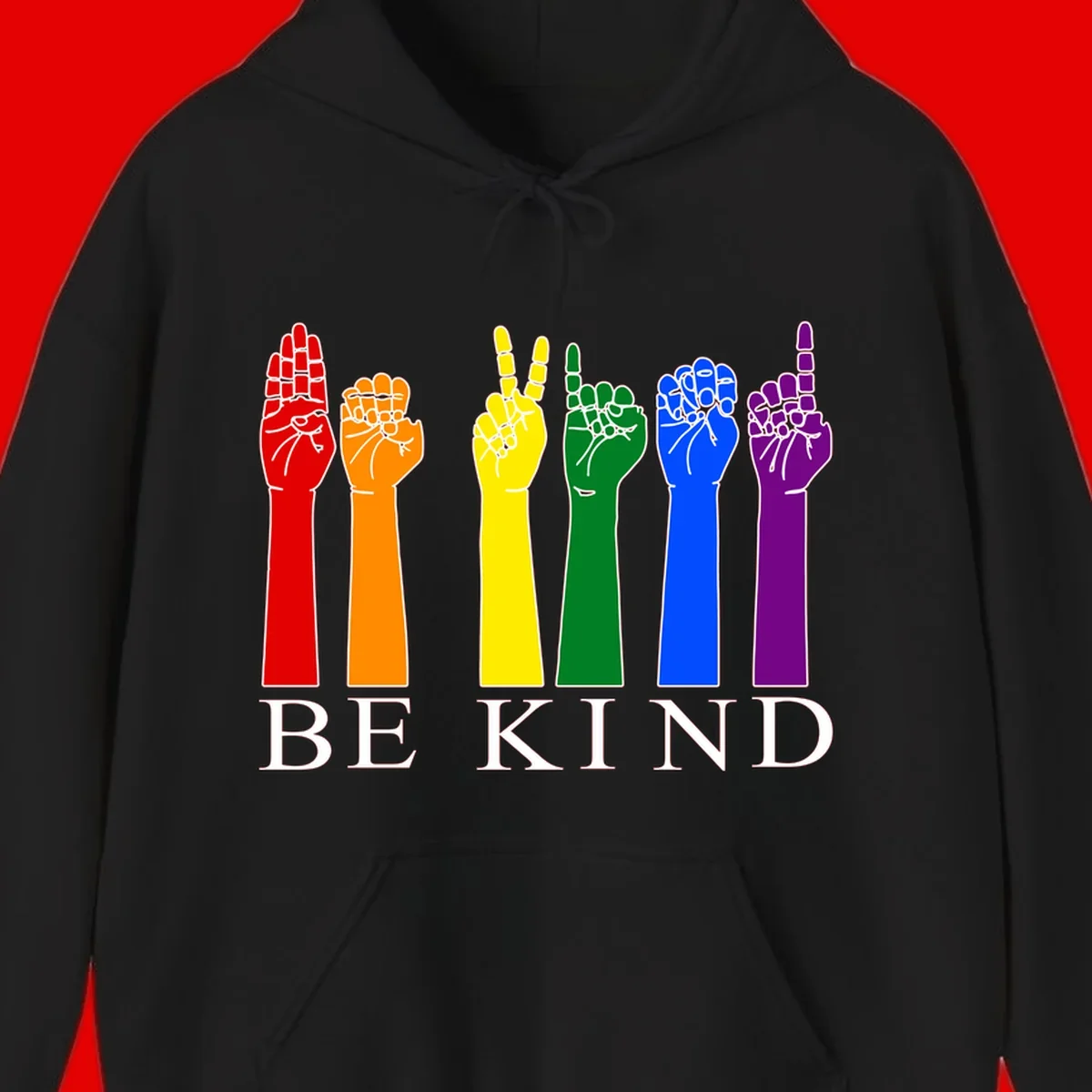 Six rainbow-colored raised hands in red, orange, yellow, green, blue, and purple with white line details and 'BE KIND' text below