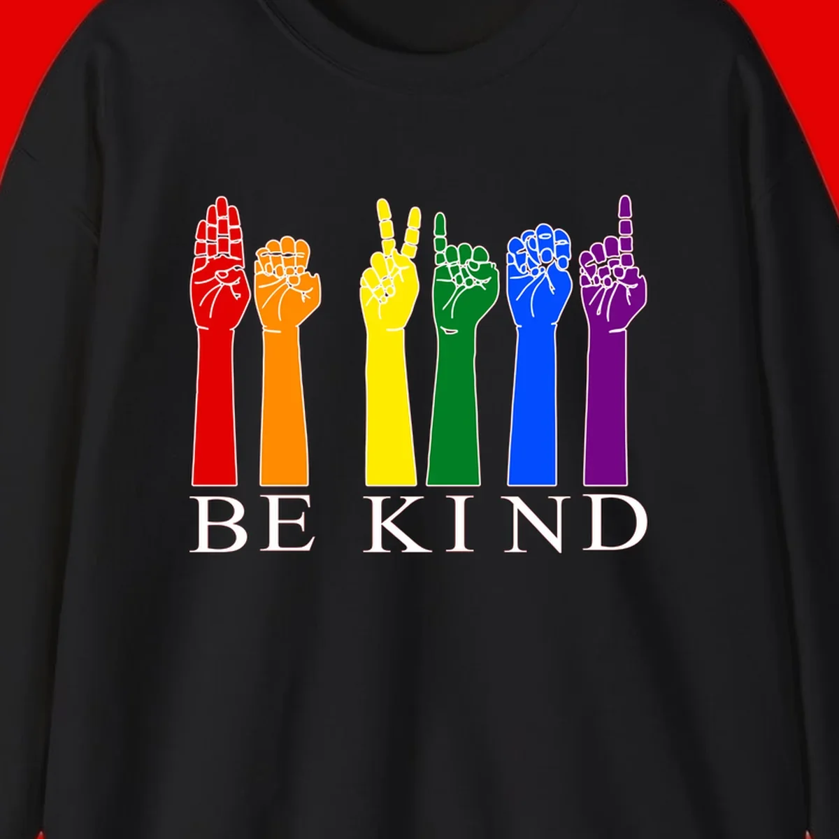 Six rainbow-colored raised hands in red, orange, yellow, green, blue, and purple with white line details and 'BE KIND' text below