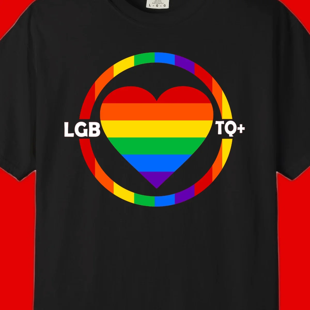 Rainbow heart with LGB TO+ text in concentric pride circles on gray background
