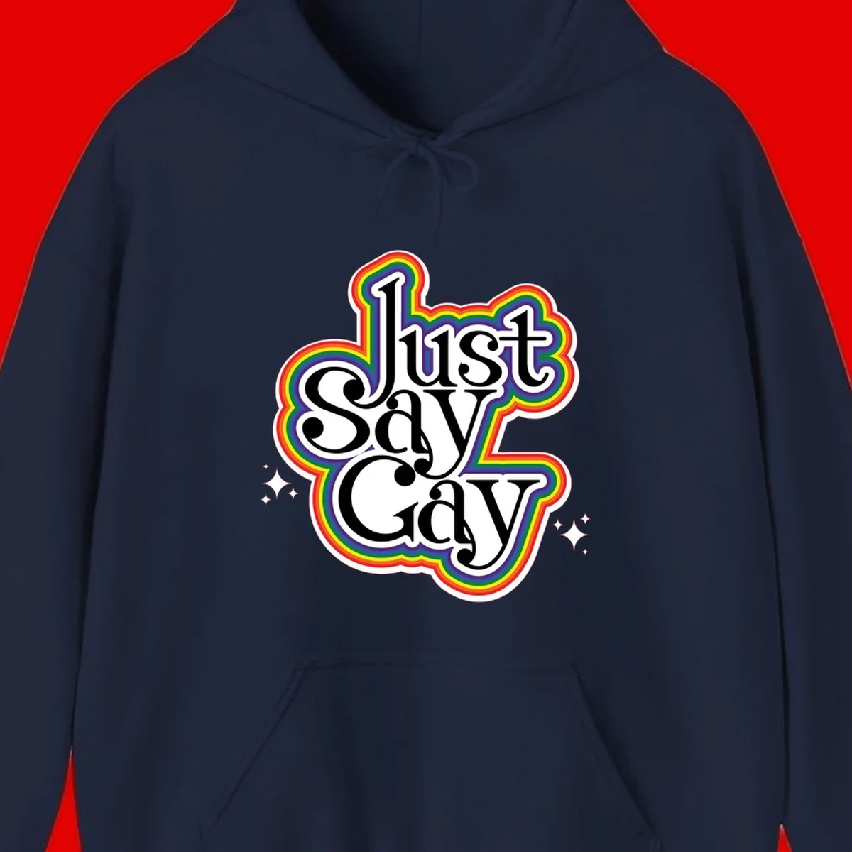 Just Say Gay Pride design with bold black text surrounded by vibrant rainbow border and sparkle accents on gray background