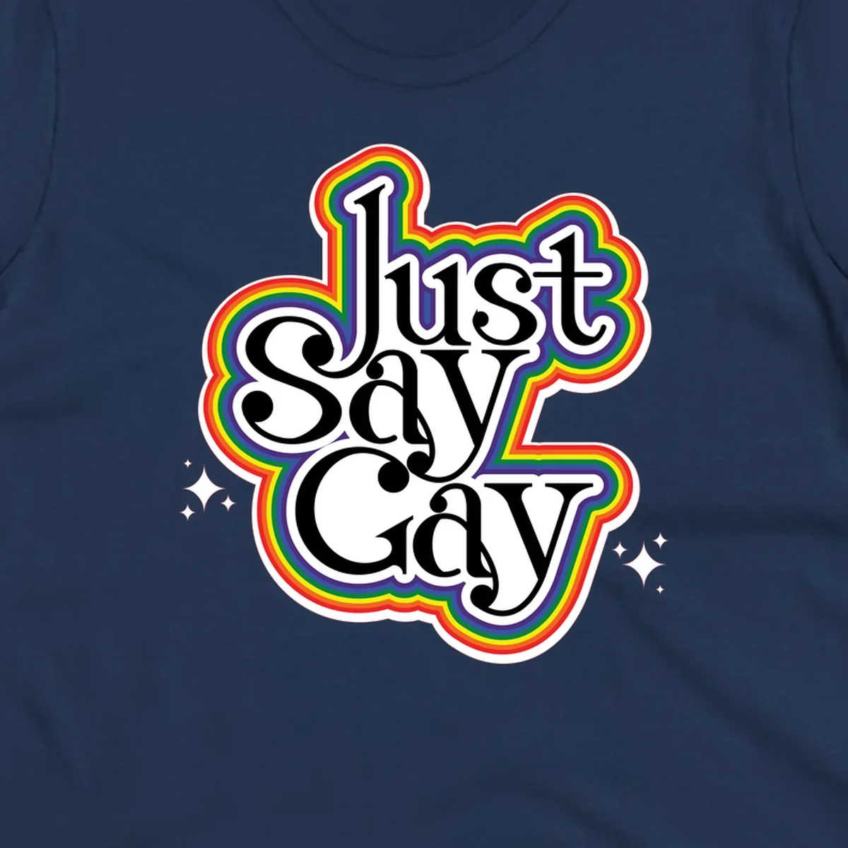 Just Say Gay Pride design with bold black text surrounded by vibrant rainbow border and sparkle accents on gray background