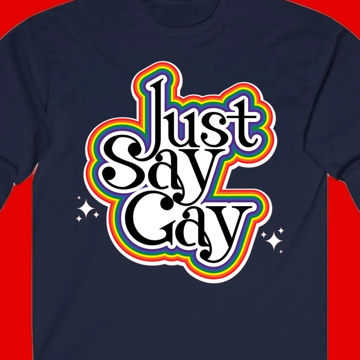 Just Say Gay Pride design with bold black text surrounded by vibrant rainbow border and sparkle accents on gray background
