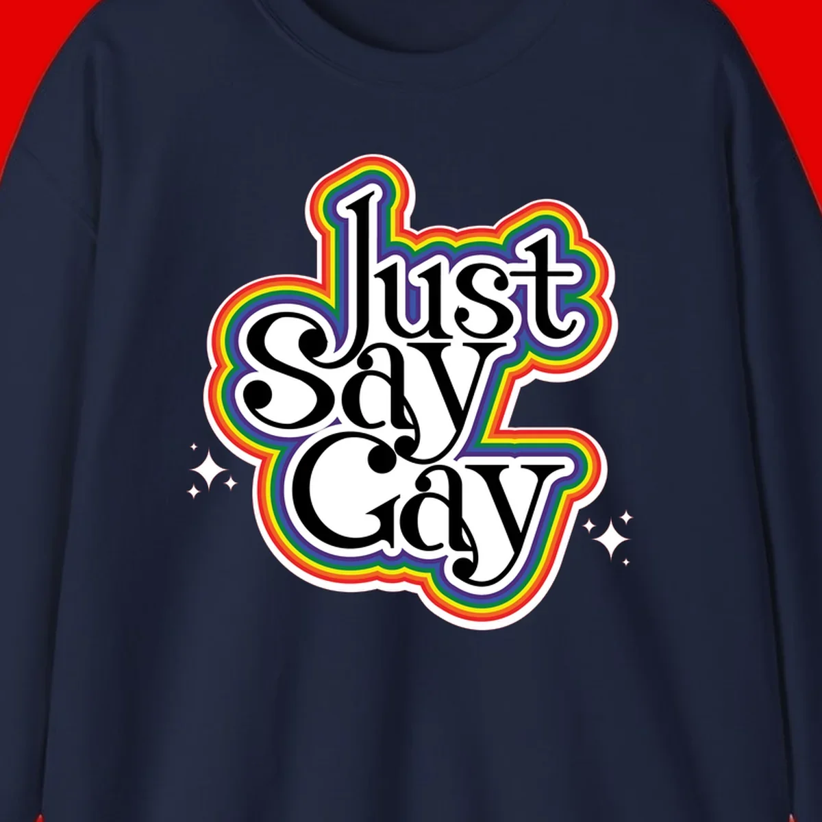 Just Say Gay Pride design with bold black text surrounded by vibrant rainbow border and sparkle accents on gray background