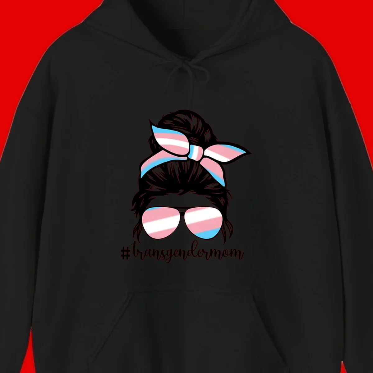 Stylized portrait with black hair, cat-eye sunglasses and bow in transgender flag colors, #transgendermom text below