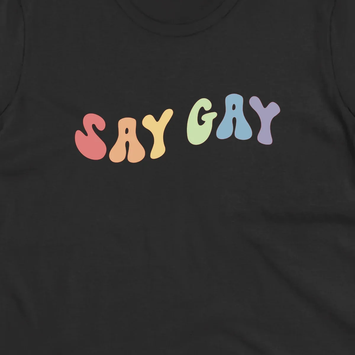 Colorful bubble letters spelling SAY GAY in rainbow pride colors: red, peach, yellow, green, blue, and purple on gray background