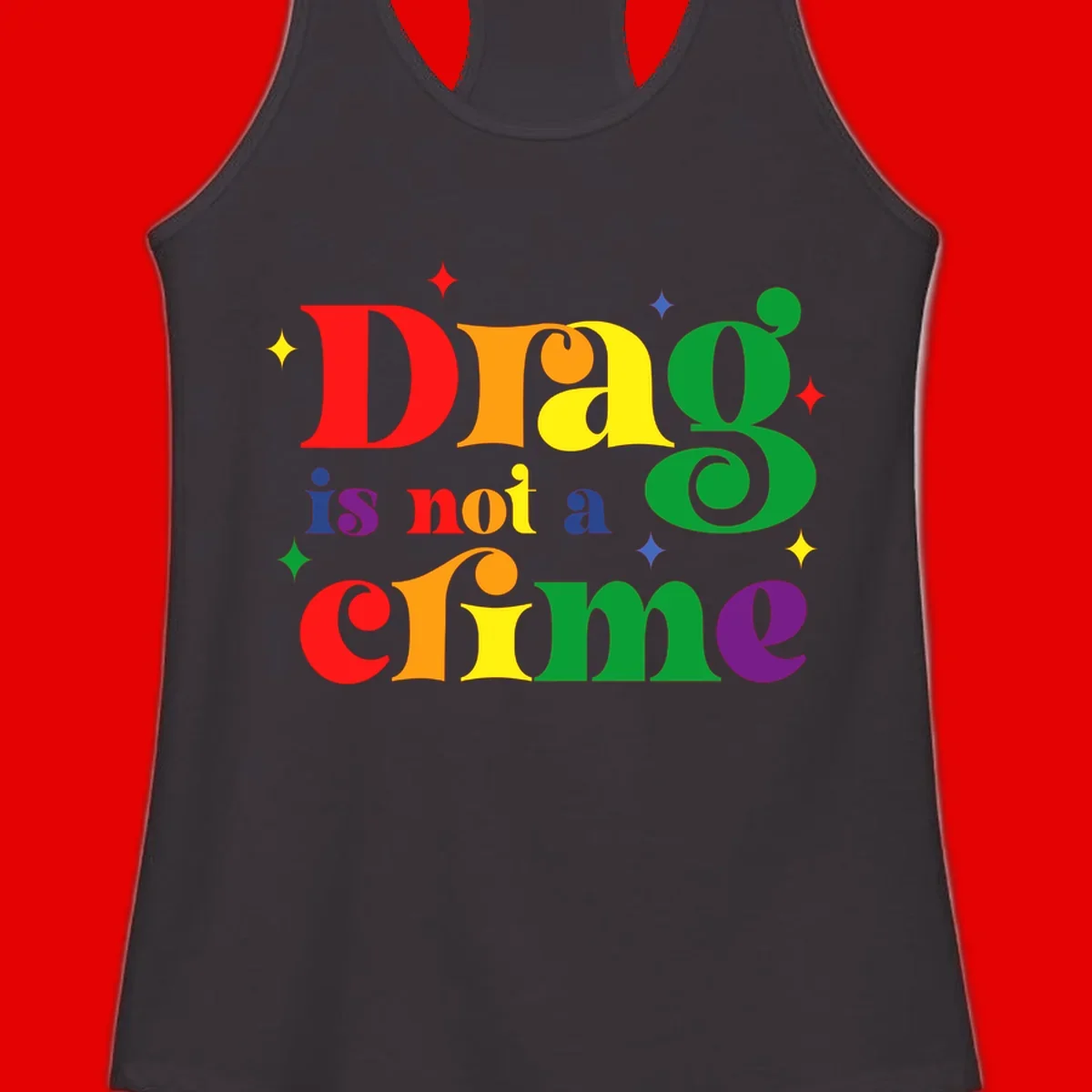 Colorful rainbow typography spelling 'Drag is not a crime' with decorative stars on gray background