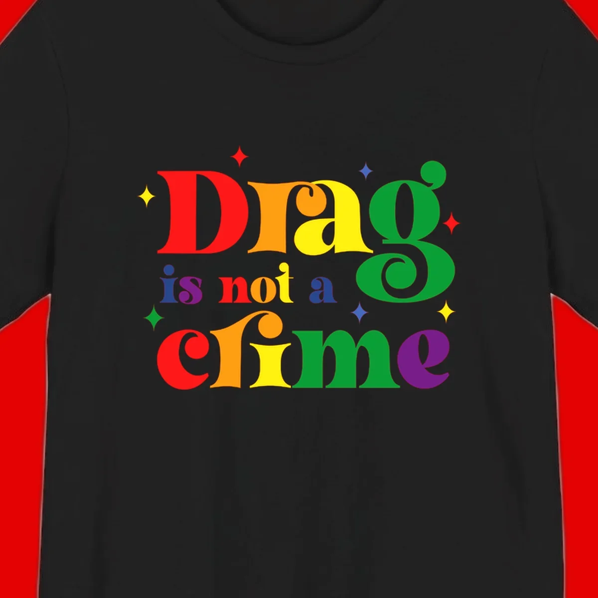 Colorful rainbow typography spelling 'Drag is not a crime' with decorative stars on gray background