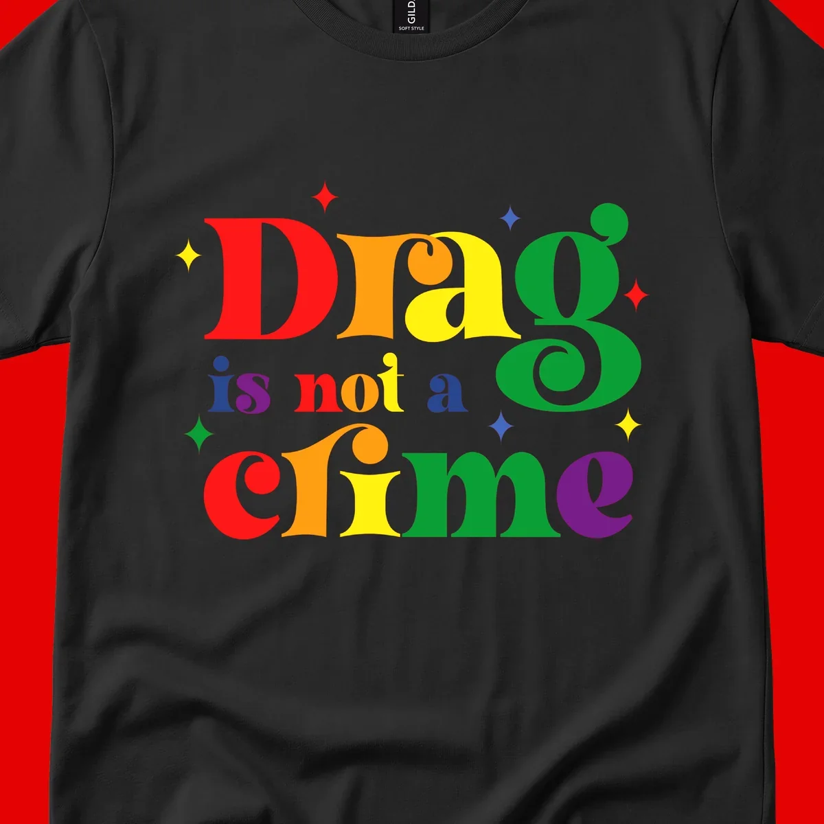 Colorful rainbow typography spelling 'Drag is not a crime' with decorative stars on gray background