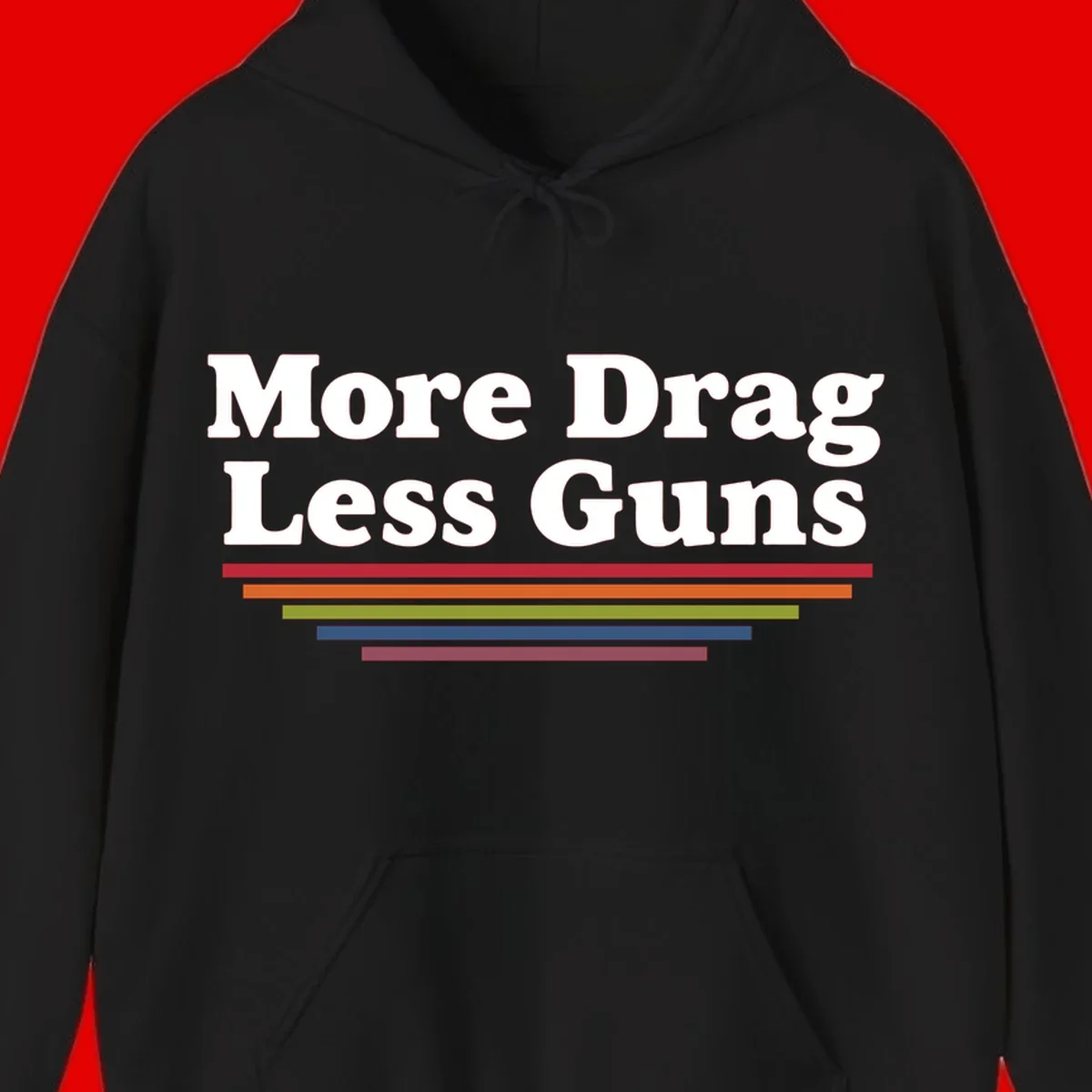 More Drag Less Guns design: white text on gray background with colored horizontal bars representing pride and activism