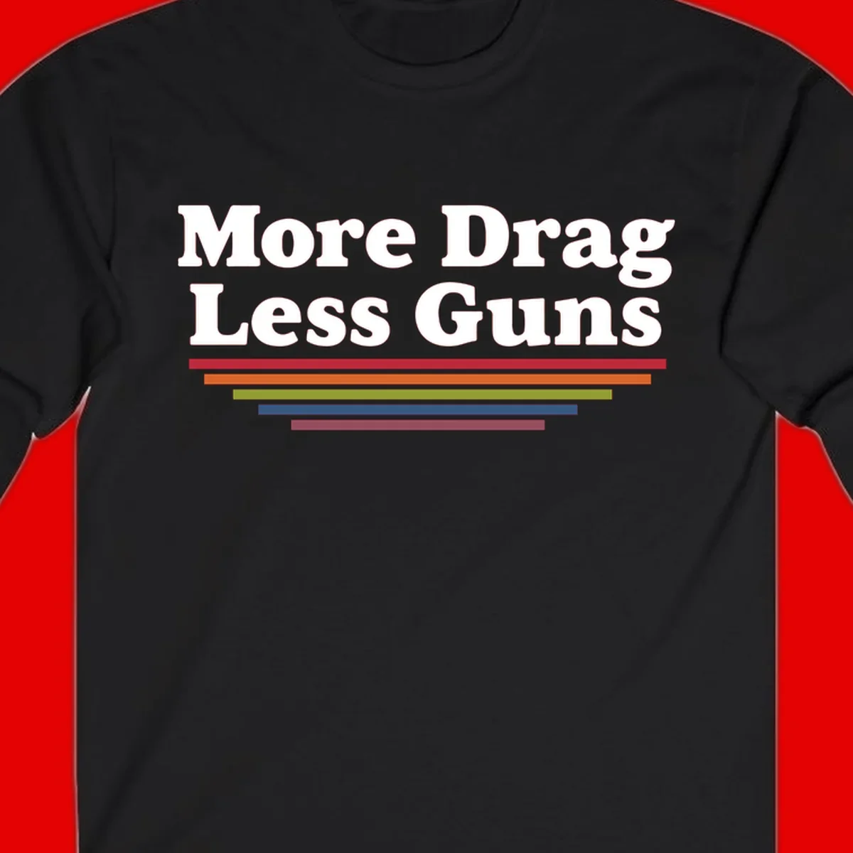 More Drag Less Guns design: white text on gray background with colored horizontal bars representing pride and activism