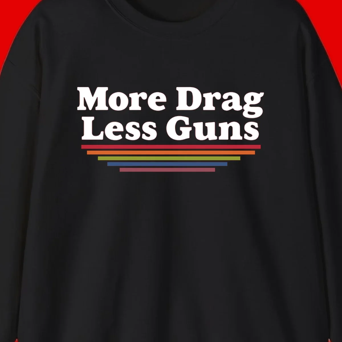 More Drag Less Guns design: white text on gray background with colored horizontal bars representing pride and activism