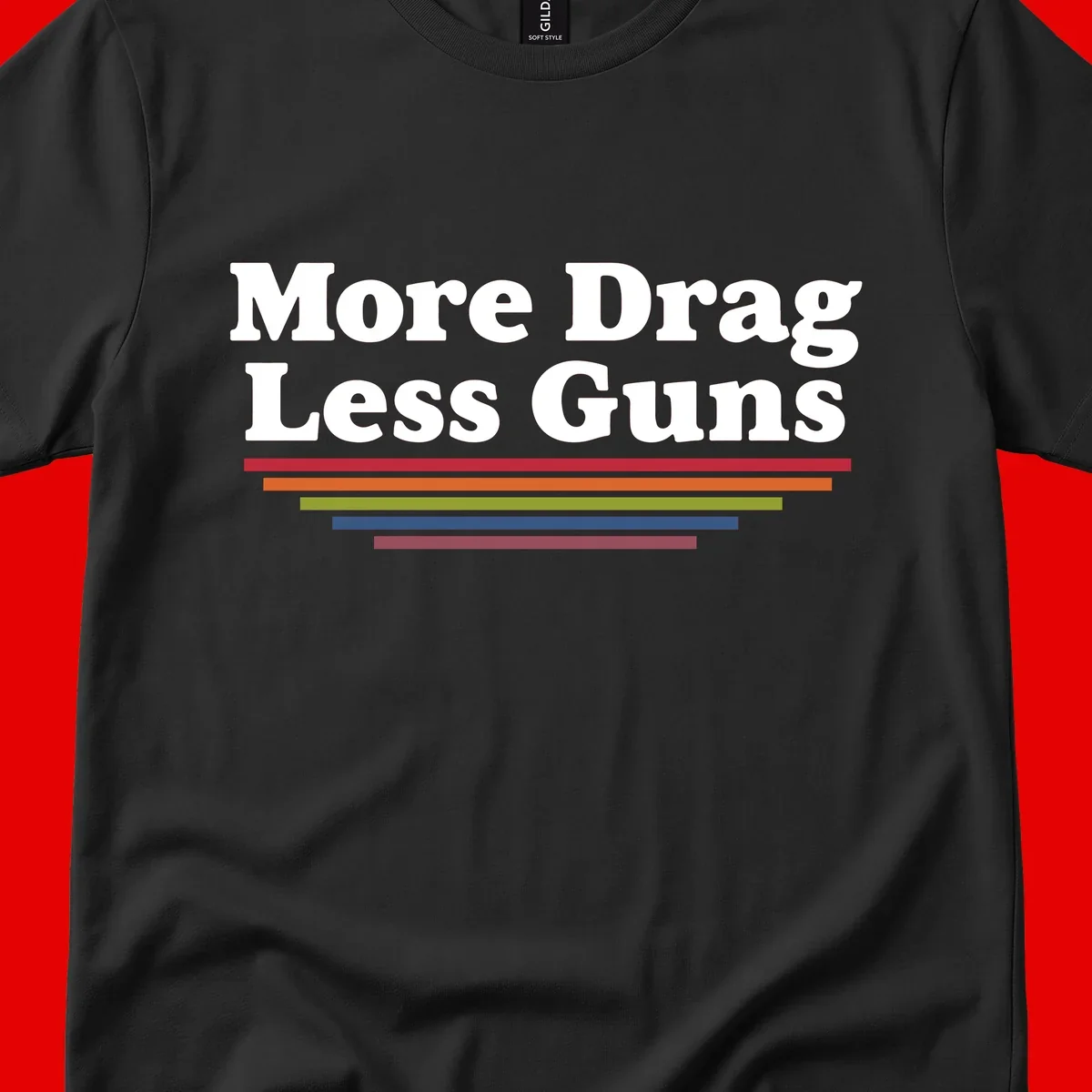 More Drag Less Guns design: white text on gray background with colored horizontal bars representing pride and activism