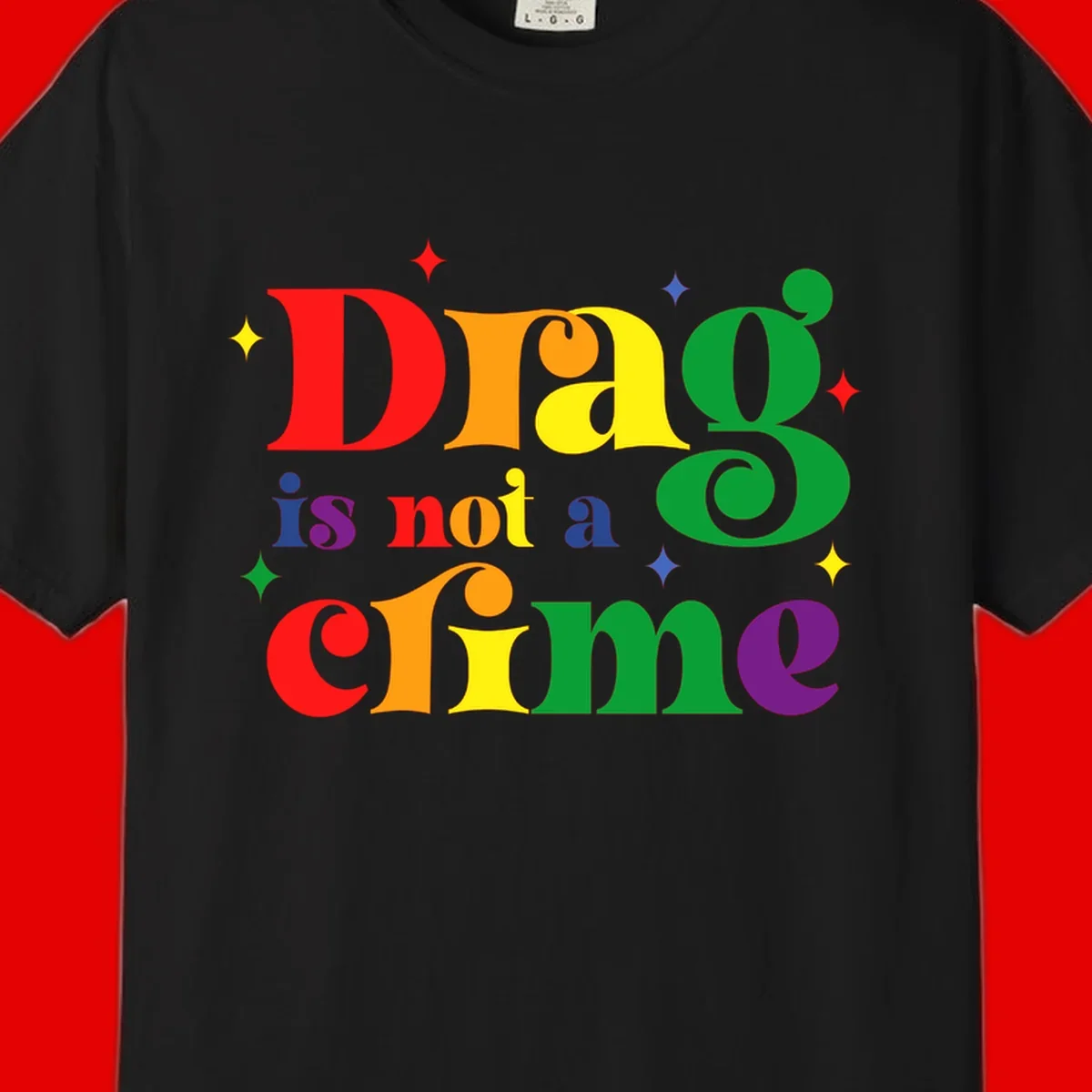 Rainbow gradient text reading 'Drag is not a crime' with colorful stars on gray background