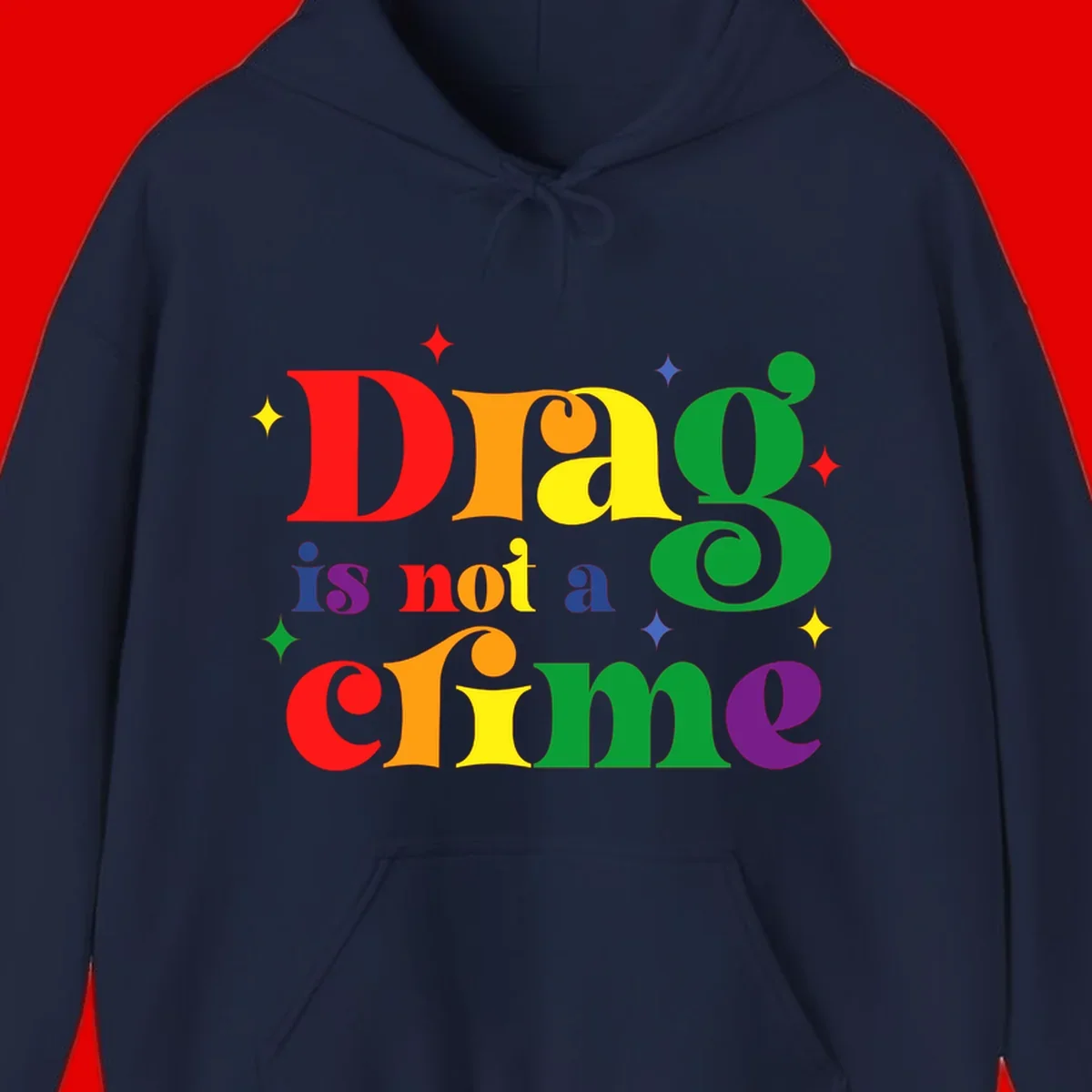 Rainbow gradient text reading 'Drag is not a crime' with colorful stars on gray background