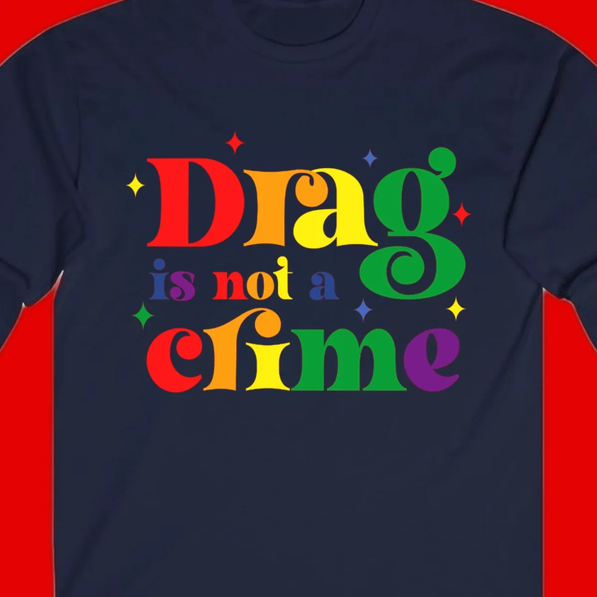 Rainbow gradient text reading 'Drag is not a crime' with colorful stars on gray background