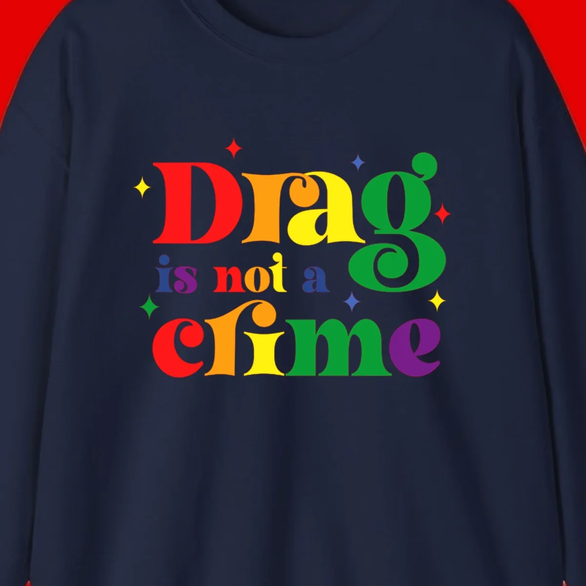 Rainbow gradient text reading 'Drag is not a crime' with colorful stars on gray background