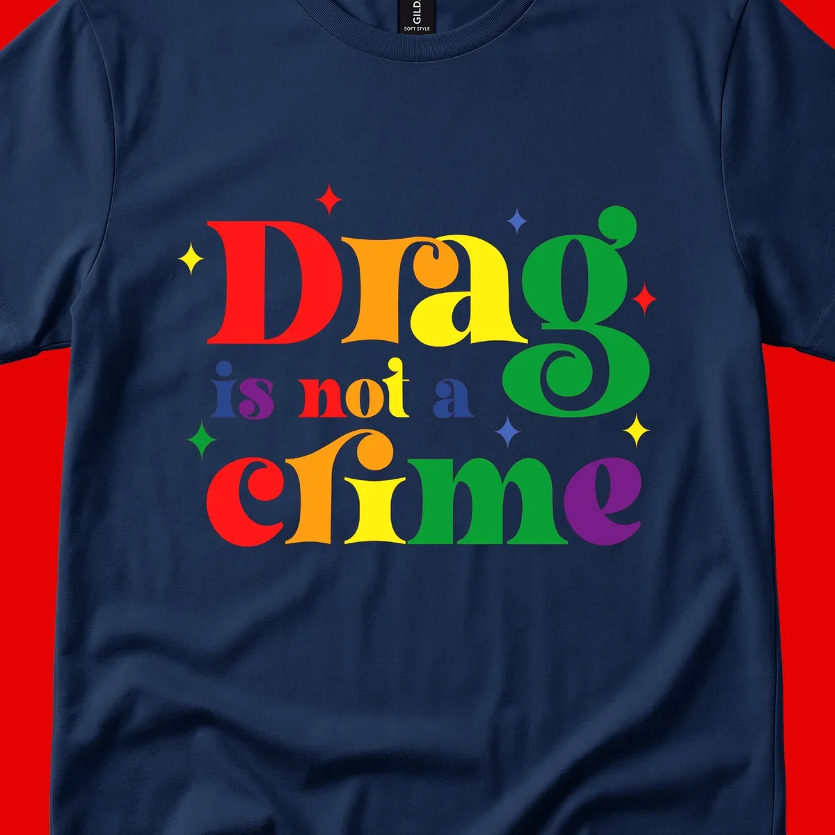 Rainbow gradient text reading 'Drag is not a crime' with colorful stars on gray background