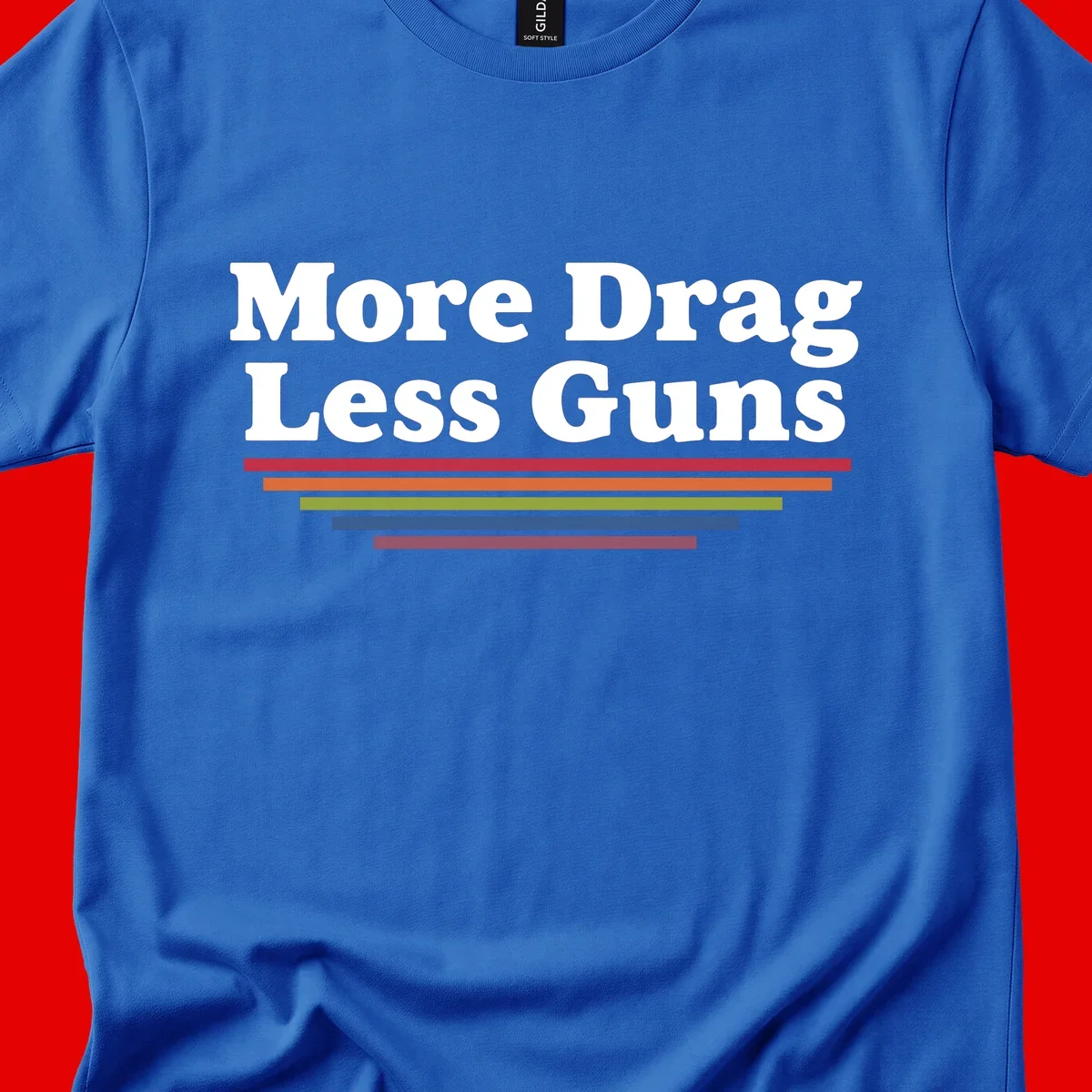 Bold white text reading 'More Drag Less Guns' with colorful horizontal bars below on gray background
