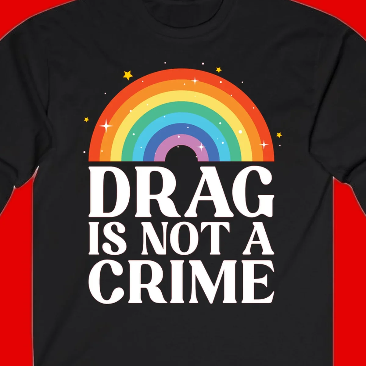 Rainbow arc with stars and text reading 'Drag Is Not A Crime' - a pride-themed design celebrating drag rights and LGBTQ+ equality