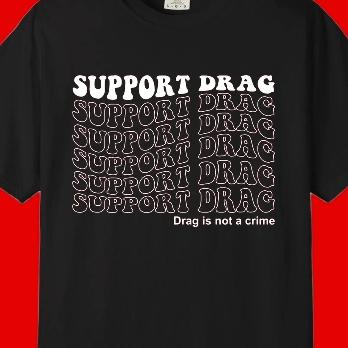 Gray shirt design with white text reading 'Support Drag' repeated vertically and 'Drag is not a crime' at bottom