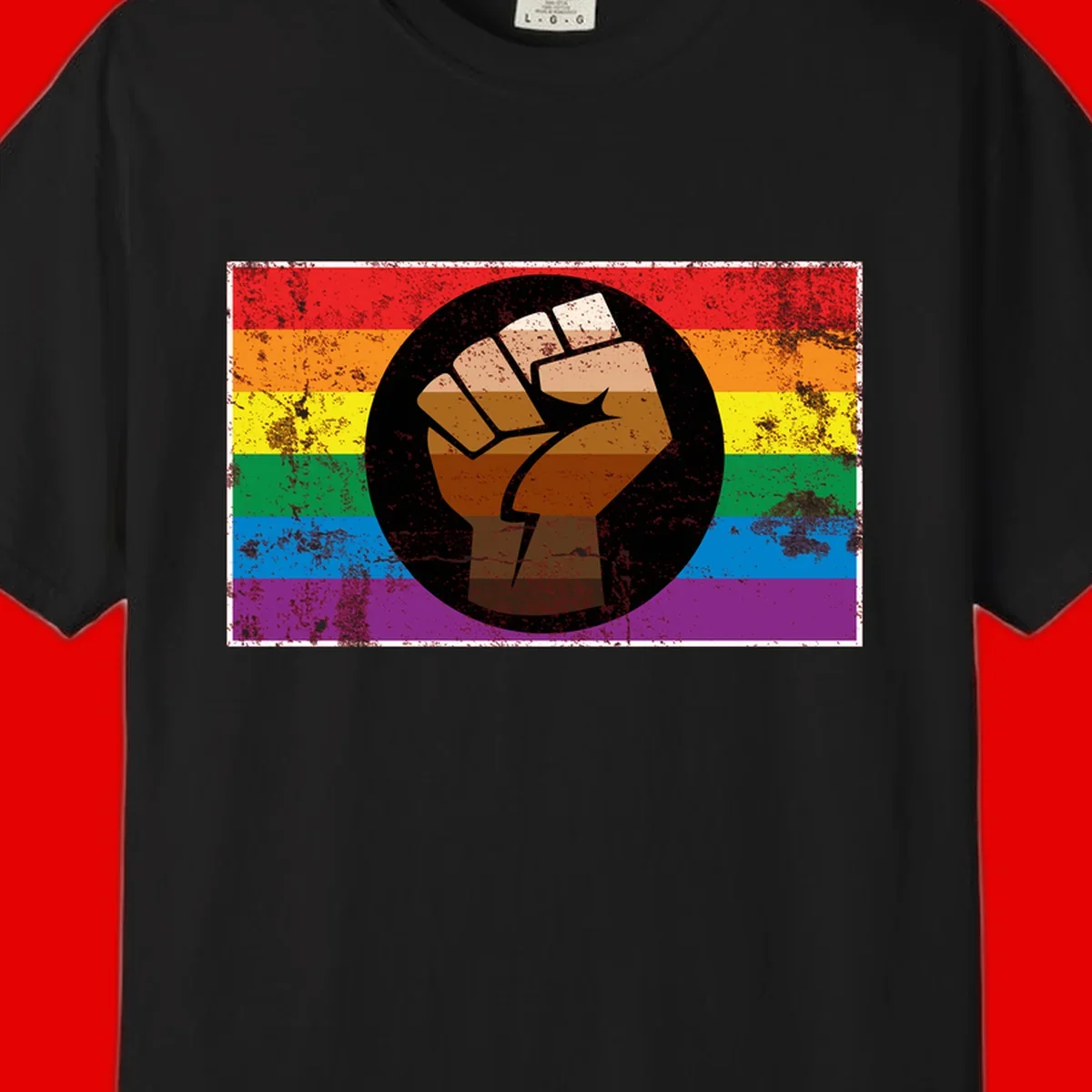 Distressed circular badge featuring a raised brown fist overlaid on a rainbow pride flag background, symbolizing LGBTQ+ solidarity and empowerment