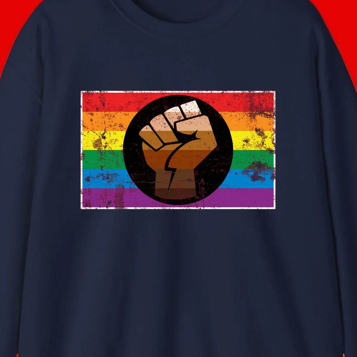 Distressed circular badge featuring a raised brown fist overlaid on a rainbow pride flag background, symbolizing LGBTQ+ solidarity and empowerment