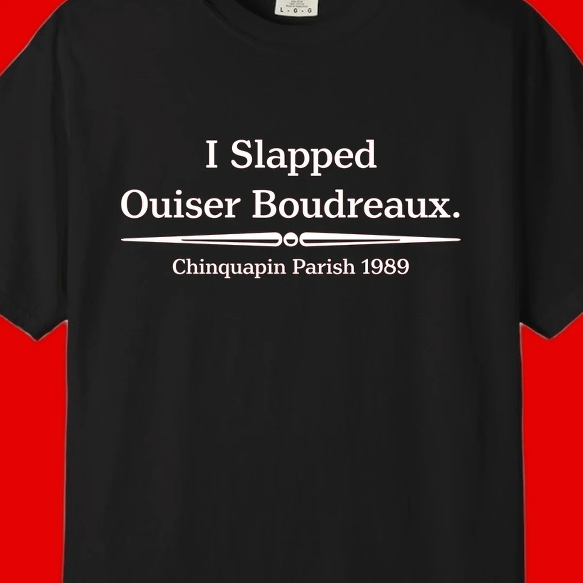 White text on gray background reading 'I Slapped Ouiser Boudreaux. Chinquapin Parish 1989' with decorative line divider