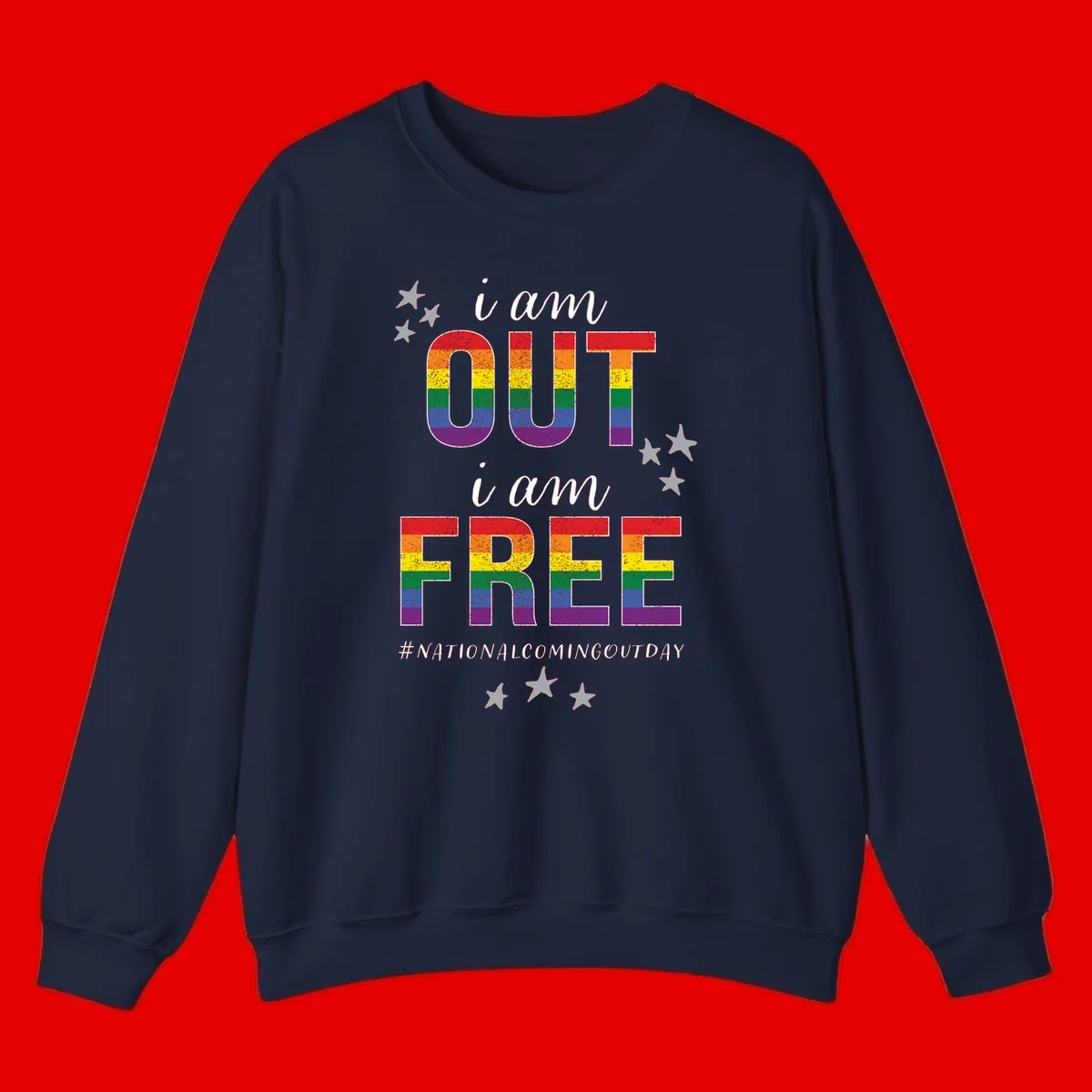 Rainbow-striped letters spelling 'i am OUT i am FREE' with decorative stars on gray background celebrating National Coming Out Day pride.