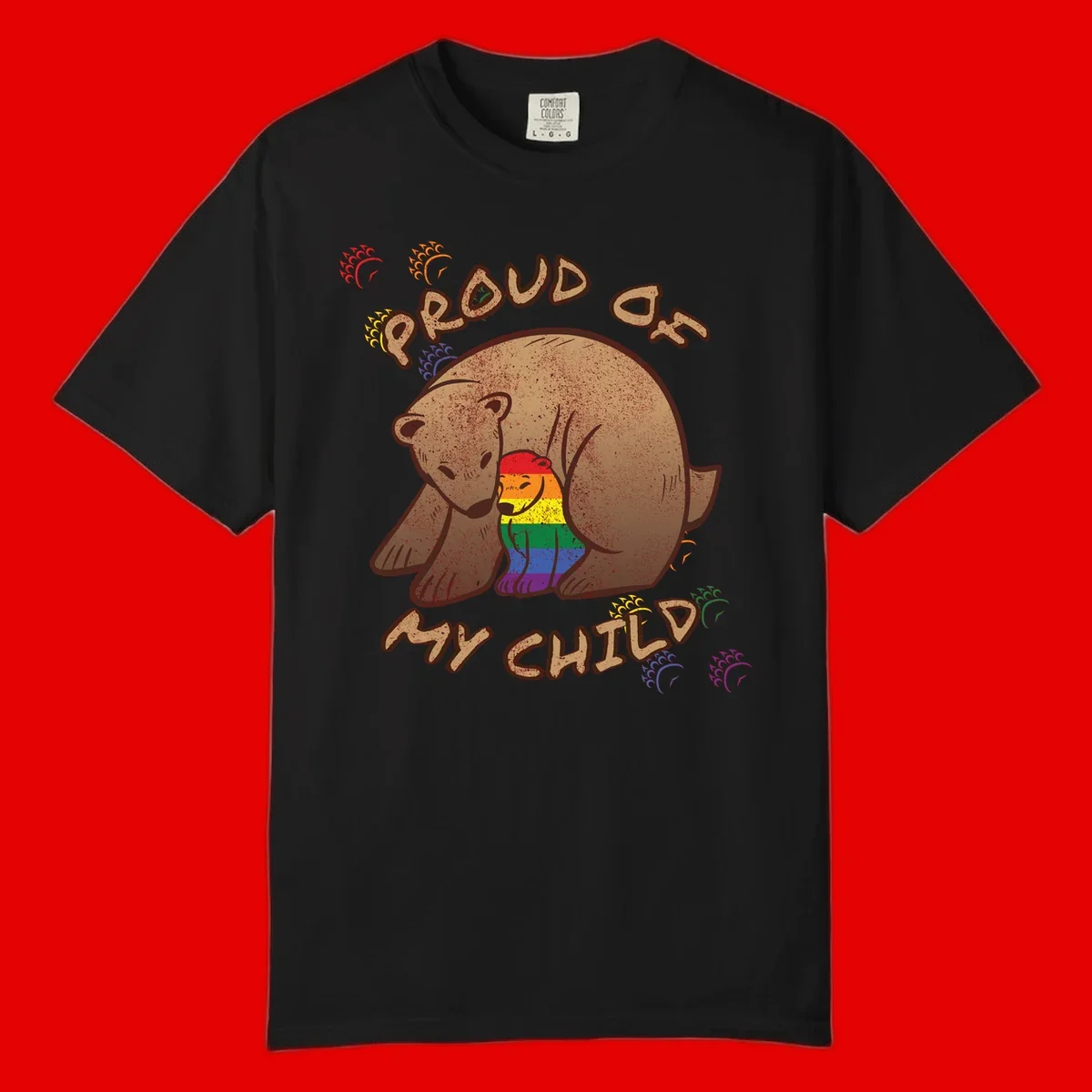 Brown bear proudly displaying rainbow pride colors with 'Proud As Shit' text and decorative bursts