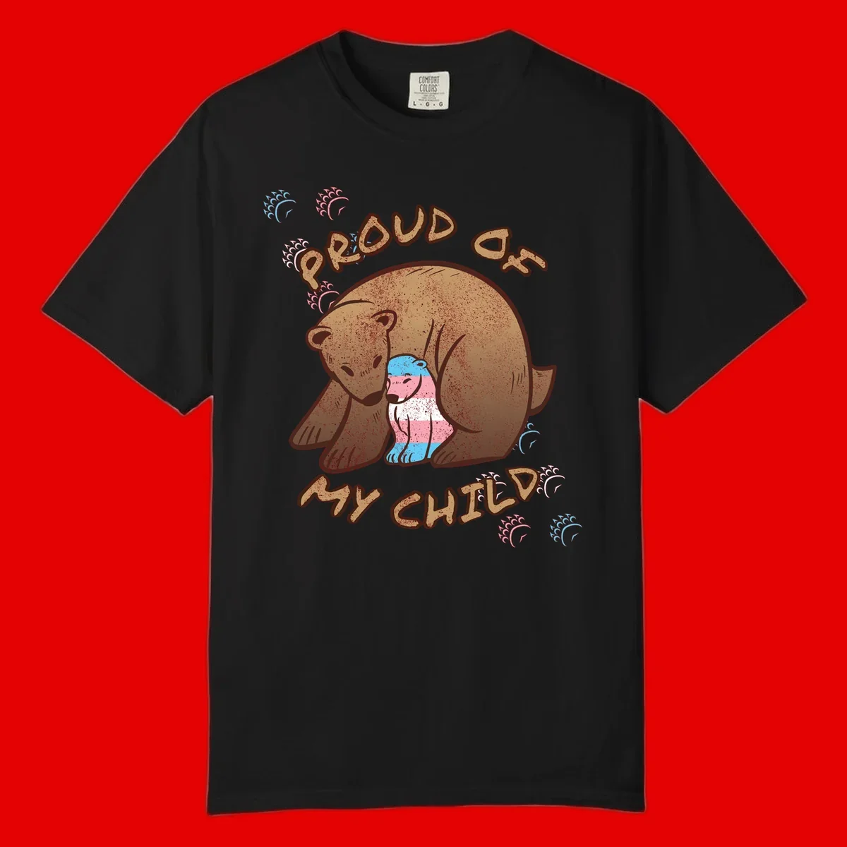 Brown bear holding a cub with blue, pink and white stripes, surrounded by 'Proud As My Chubby' text and decorative wave designs celebrating transgender pride