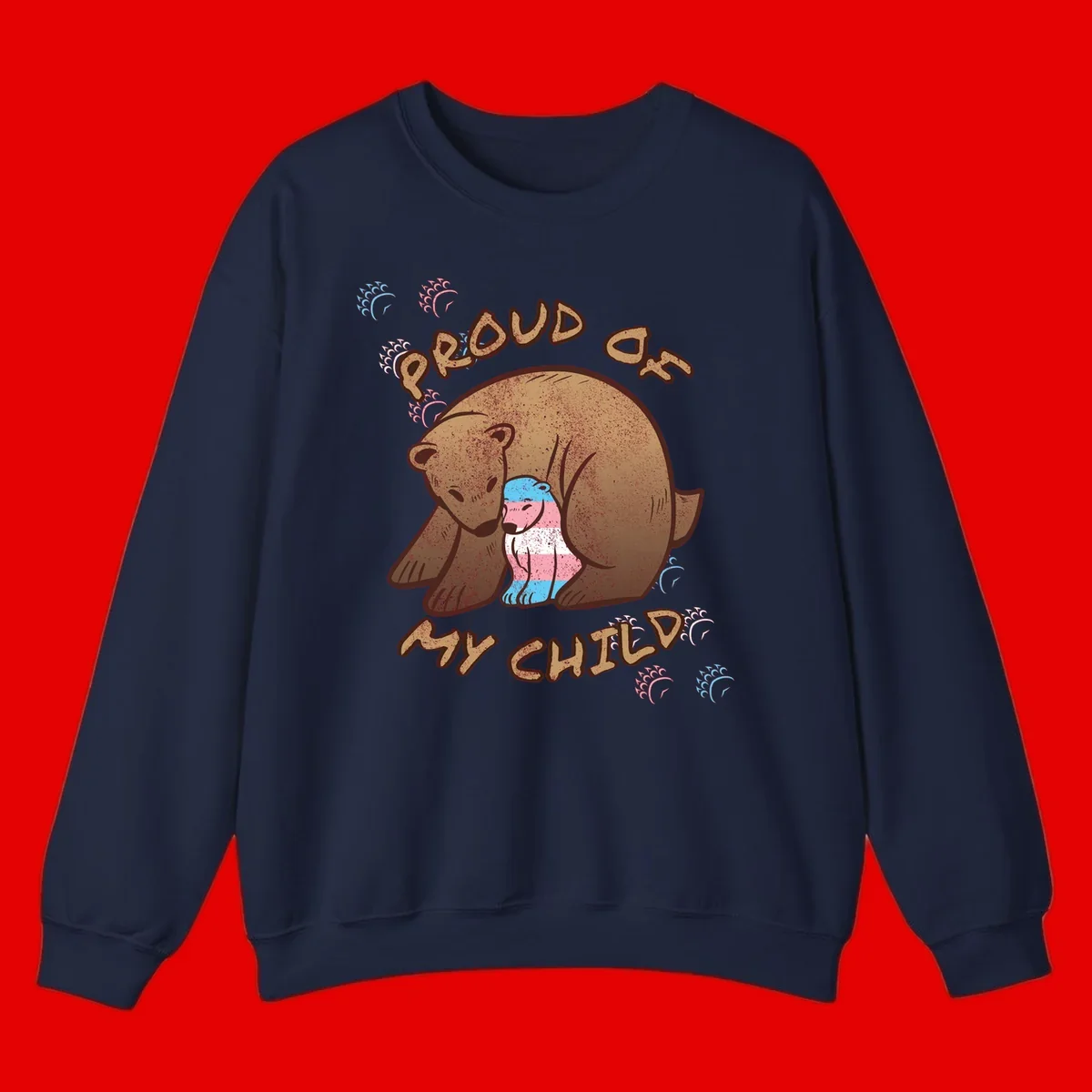 Brown bear holding a cub with blue, pink and white stripes, surrounded by 'Proud As My Chubby' text and decorative wave designs celebrating transgender pride