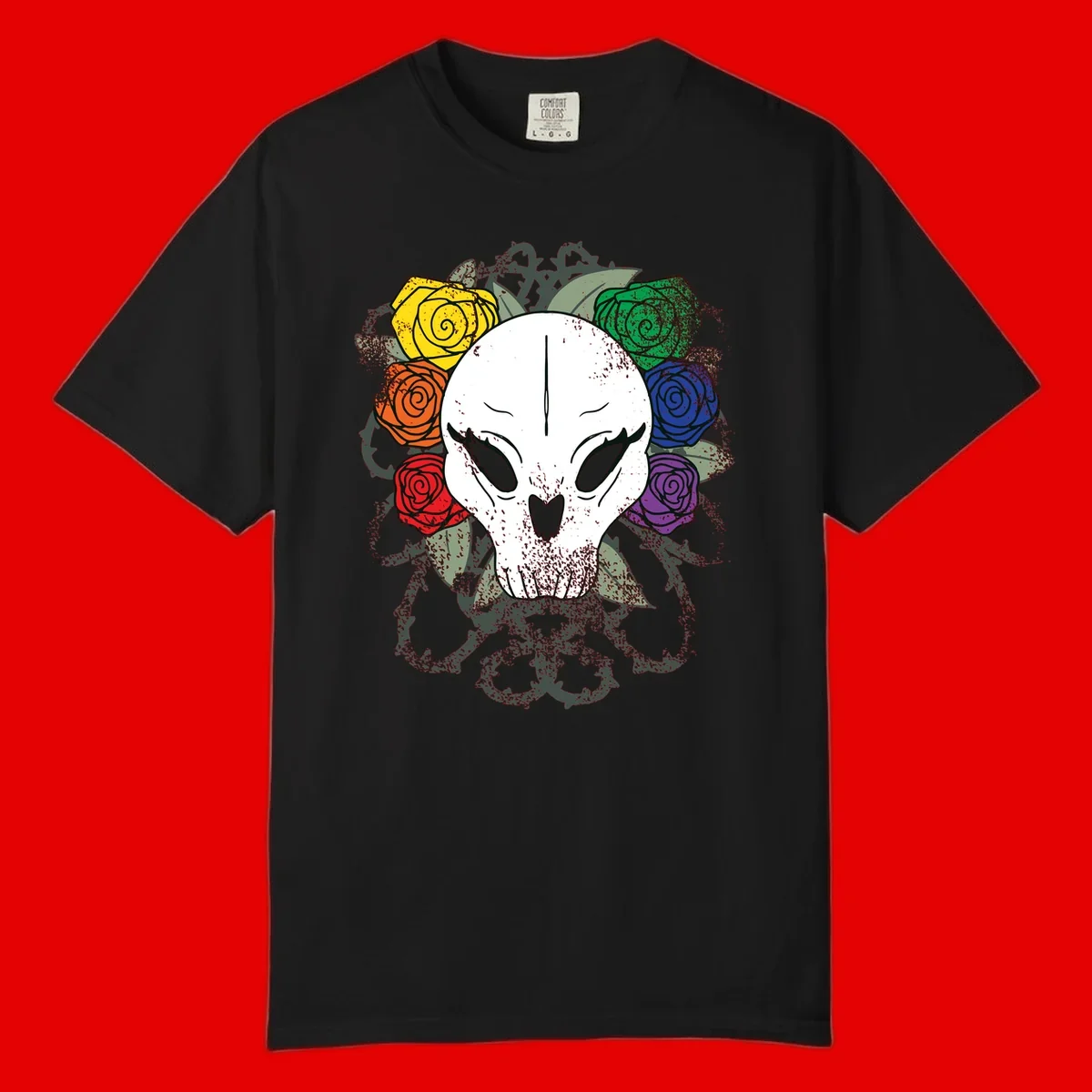 White skull with rainbow colored roses in yellow, orange, red, blue, green, and purple surrounding it on gray background