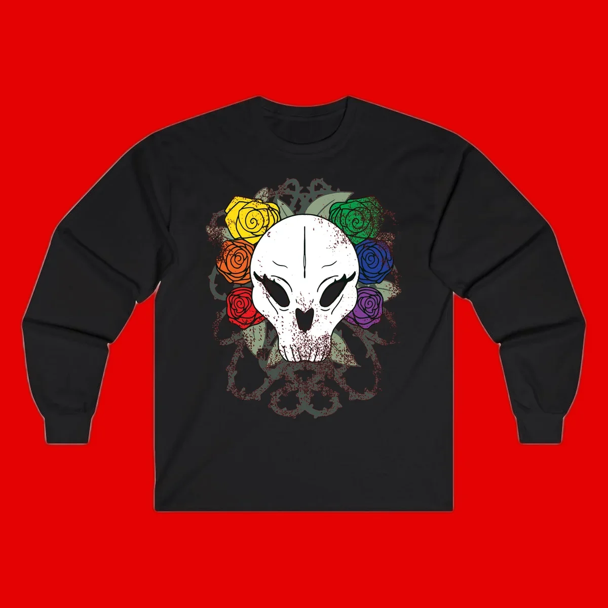 White skull with rainbow colored roses in yellow, orange, red, blue, green, and purple surrounding it on gray background