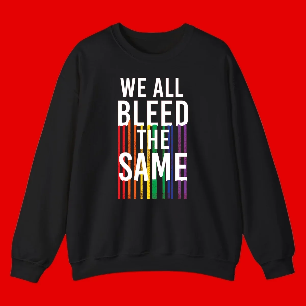White bold text 'We All Bleed The Same' over rainbow vertical stripes in pride flag colors on gray background