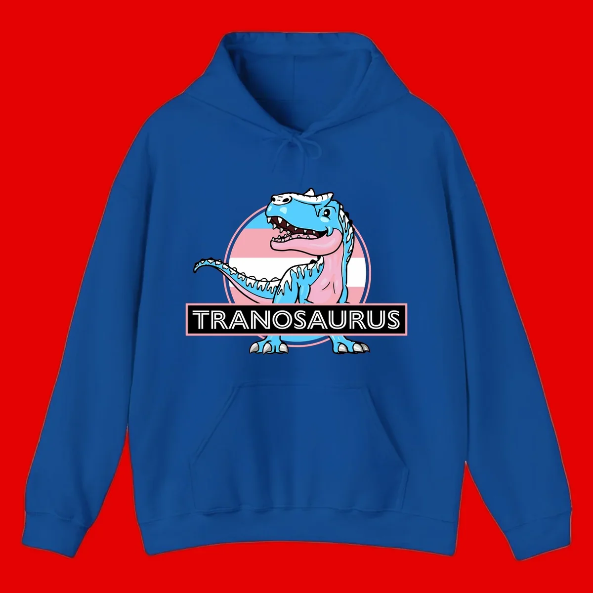 Blue cartoon T-Rex dinosaur with open mouth against pink and white pride flag circular background, labeled Tranosaurus