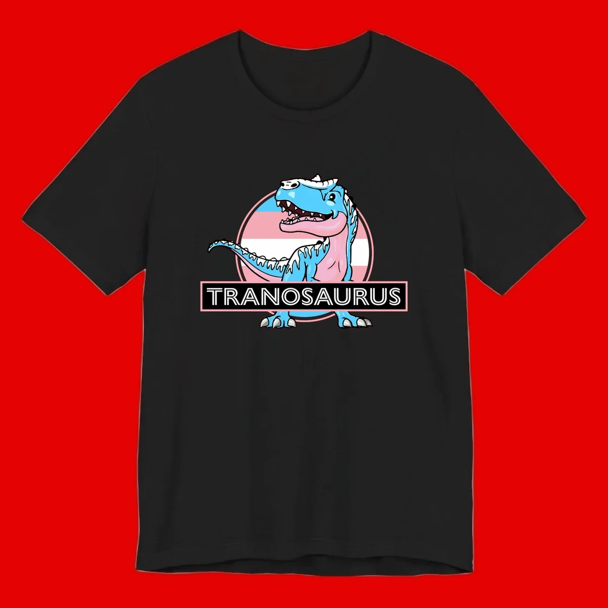 Blue cartoon T-Rex dinosaur with open mouth against pink and white pride flag circular background, labeled Tranosaurus