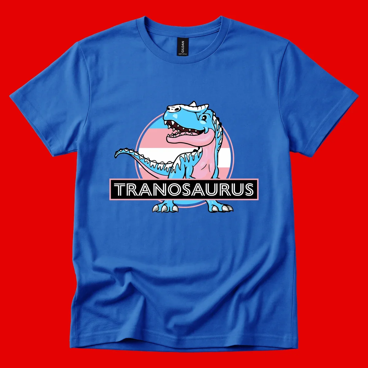 Blue cartoon T-Rex dinosaur with open mouth against pink and white pride flag circular background, labeled Tranosaurus