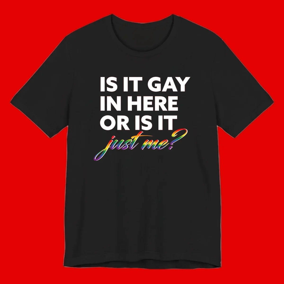 Bold white text reading "Is It Gay In Here Or Is It" with rainbow gradient lettering spelling "just me?" featuring pride flag colors on gray background