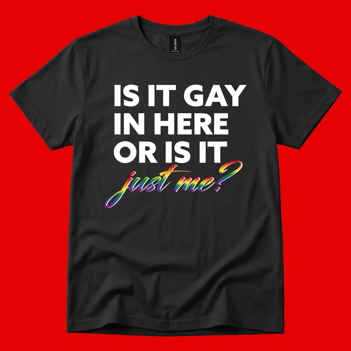 Bold white text reading "Is It Gay In Here Or Is It" with rainbow gradient lettering spelling "just me?" featuring pride flag colors on gray background